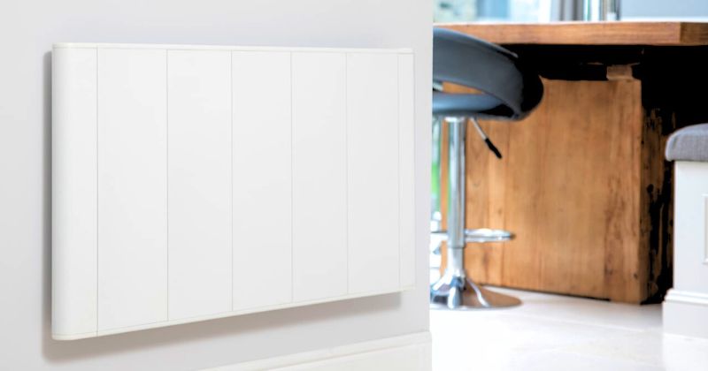 A white bestselling electric radiator is being installed on a wall near the dining area of a house.